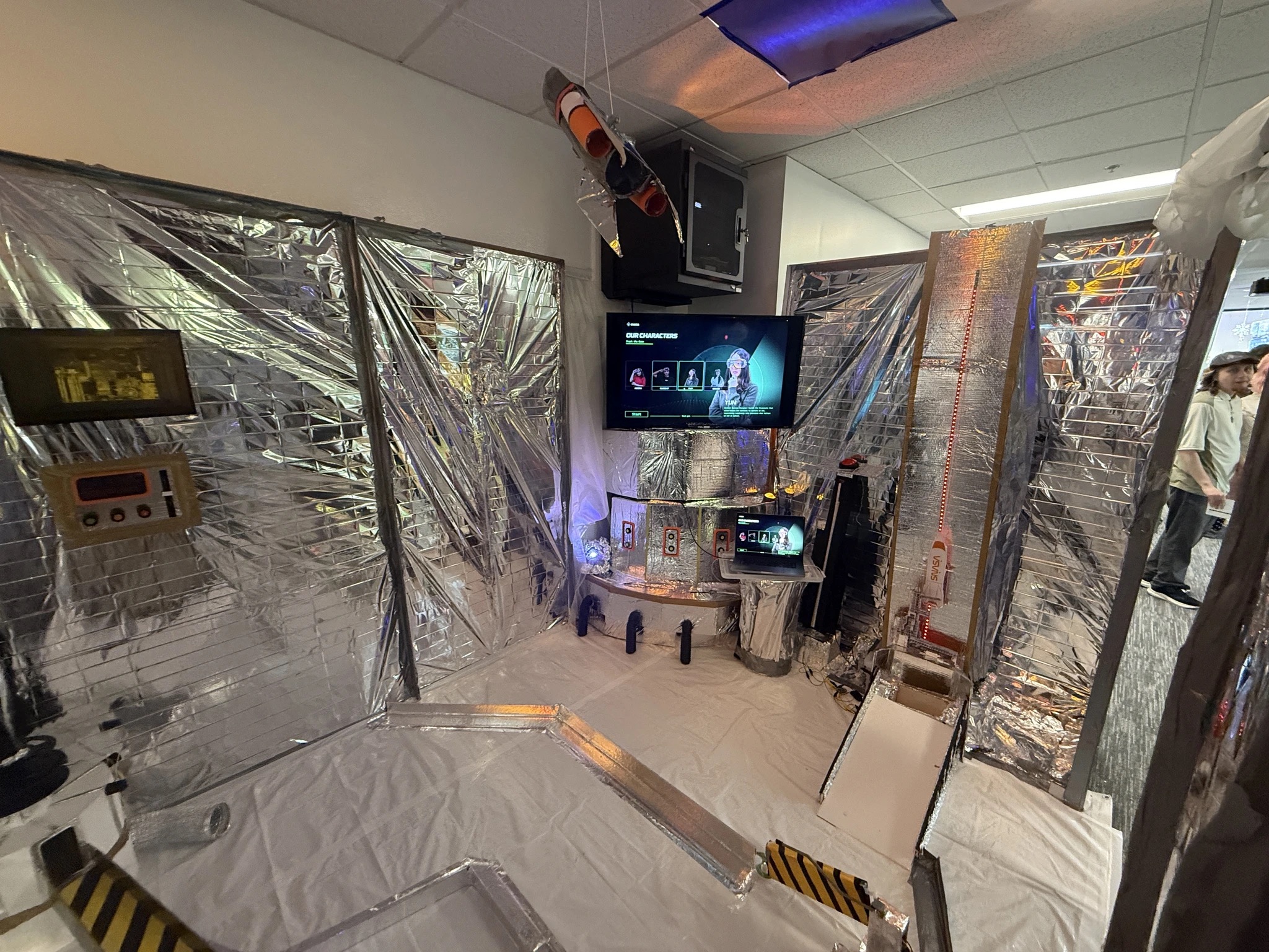Finished SNASA mini-golf hole with foil walls, screens, and a hanging rocket